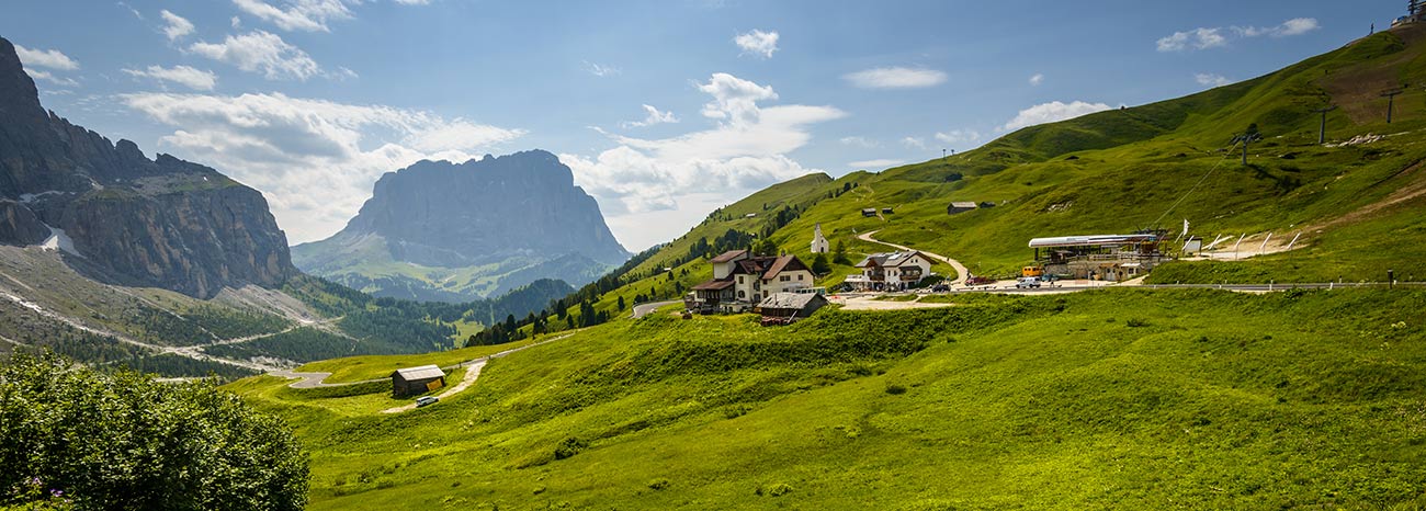 Grüne Wiesen und Berge in Gröden an einem sonnigen Tag