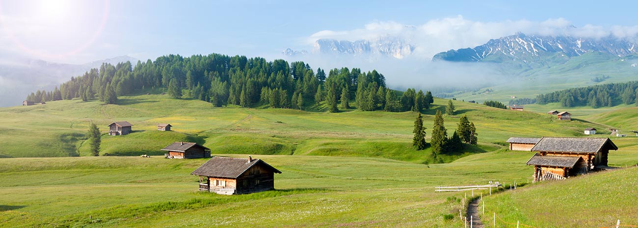 Die Seiseralm mit kleinen Holz-Hütten hier und da