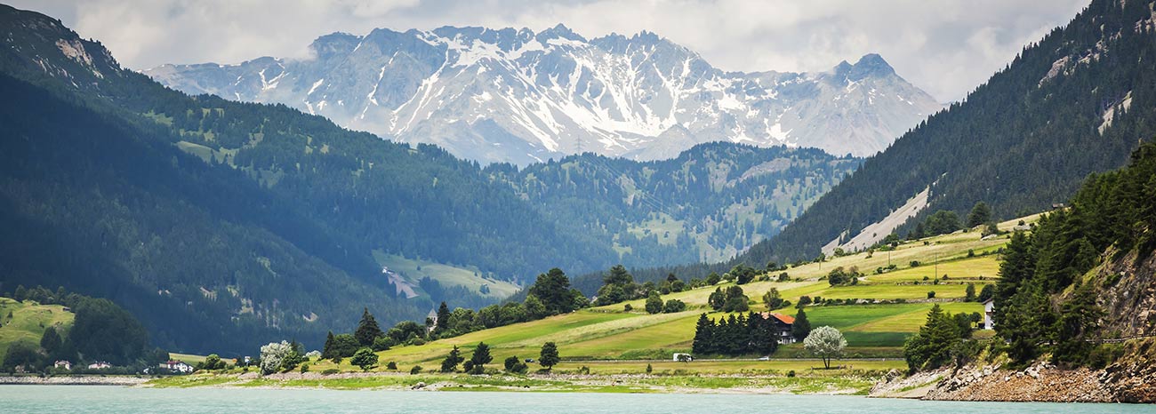 Der Reschensee umgeben von hohen, schneebedeckten Bergen